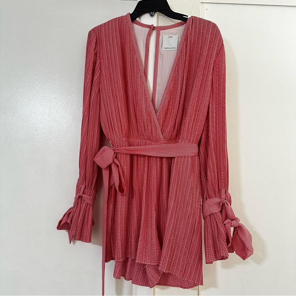 V neckline, long sleeves, and a tie belt at the waist.